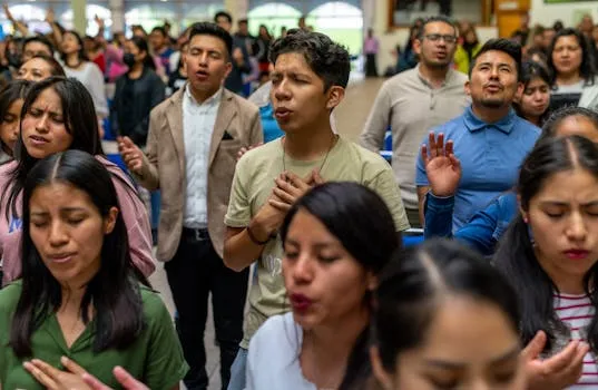 O que é religião e por que tantas pessoas a seguem? Grupo diversificado de pessoas participando de um culto espiritual